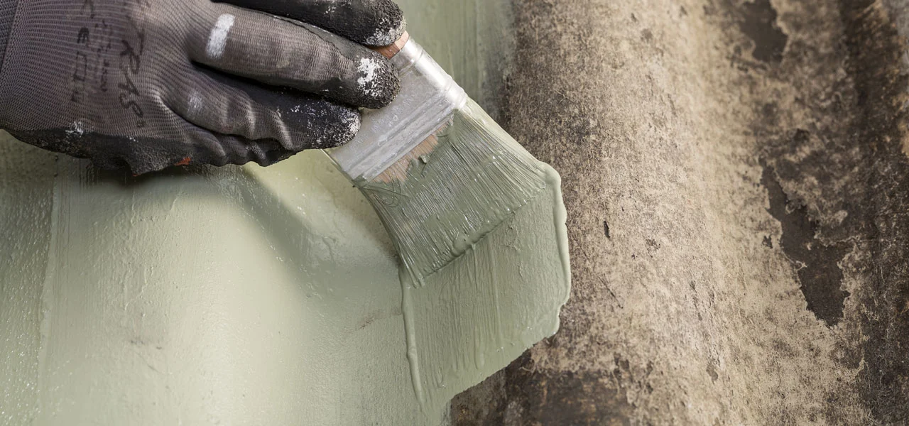 Wellblechdach wird mit einem Pinsel gestrichen