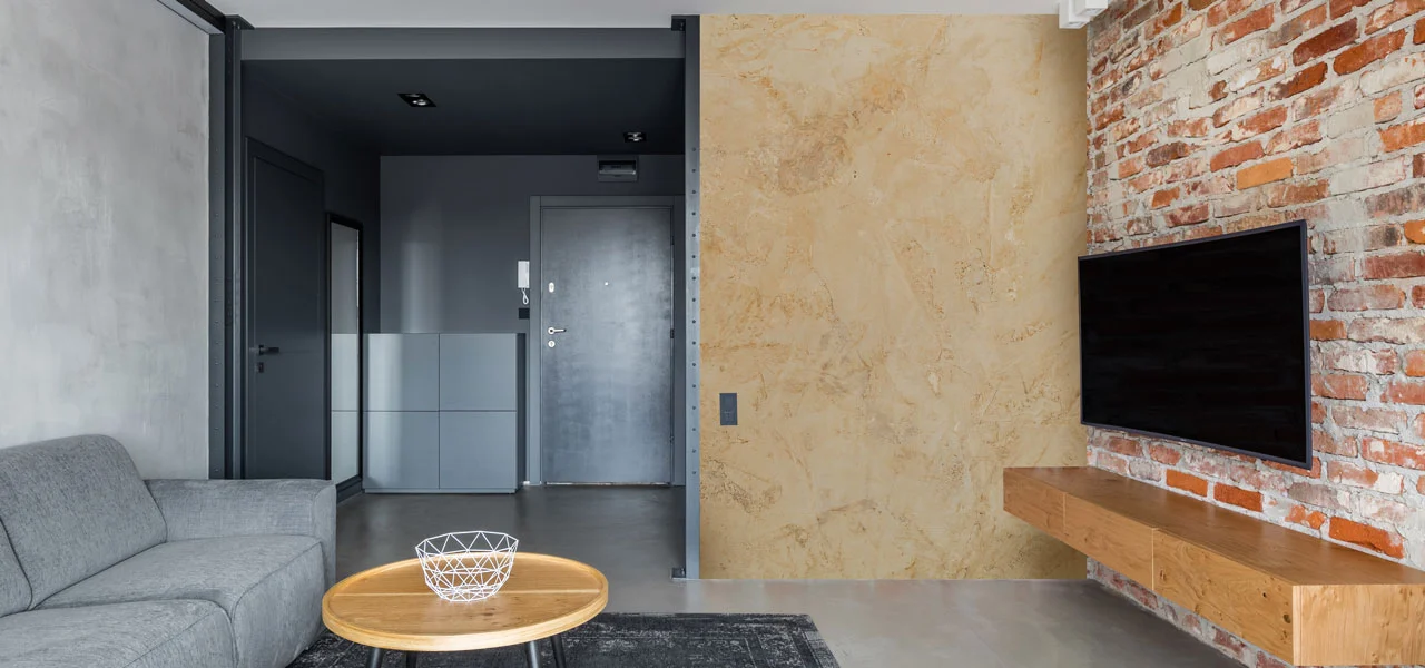 Wohnzimmer mit einer mit Calce Argilla verputzen Wand im Hintergrund