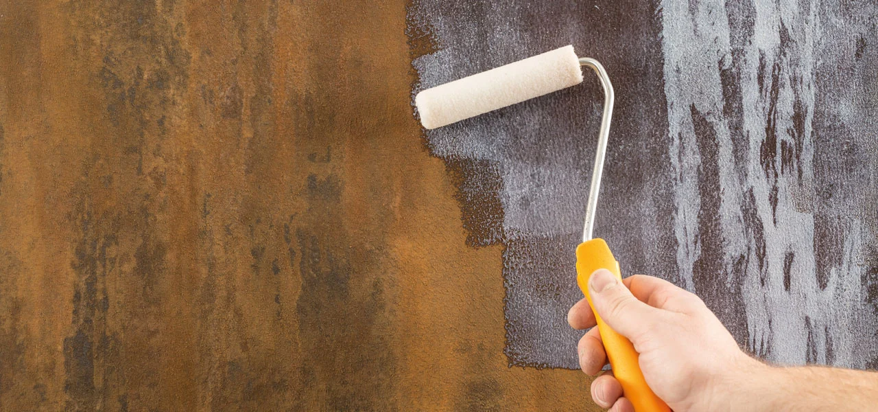 Über die Rostfarbe wird ein Siegel mit einer Walze gestrichen