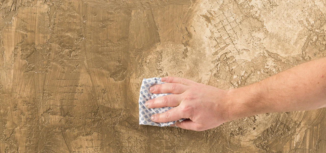 Mit einem Lappen wird die überschüssige Wachsseife vorsichtig abgetupft.