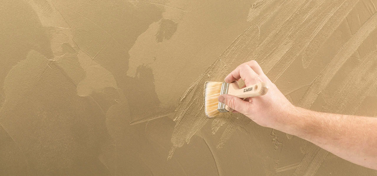 goldene Fläche wird mit einem Pinsel strukturiert